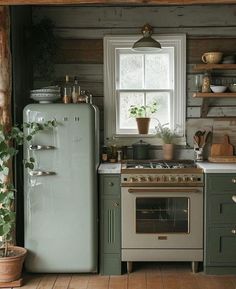 a kitchen with an oven, refrigerator and window in the wall next to potted plants