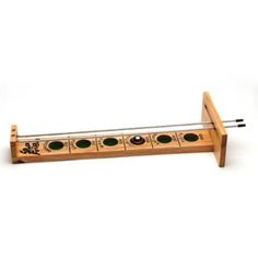 a wooden instrument with four green knobs on the front and two black knobs on the back