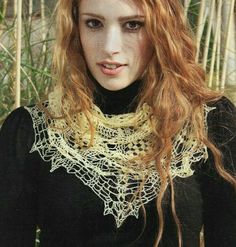 a woman with long red hair wearing a black shirt and lace neck scarf in front of bamboo trees