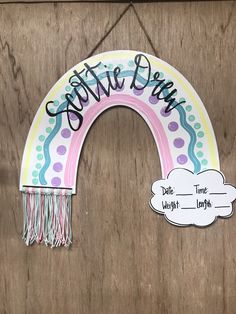 a door hanger with a rainbow painted on it