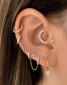 a woman wearing three different ear piercings