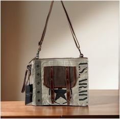 "This bag is crafted from woven canvas, with front leather accents in deep chocolate brown, that join a row of metal grommets for just the right touch. Zipper close top.  The straps are totally adjustable, use it as a shoulder purse, or lengthen the strap and use it as a crossbody.  The bag is lined with \"myra\" cotton lining and offers two inside open storage pockets and another zippered pocket. Since each bag is handcrafted, hide and canvas patterns, colors, or stitching may vary. These are t Canvas Bags With Metal Hardware For Daily Use, Brown Canvas Shoulder Bag With Snap Closure, Brown Canvas Bag With Snap Closure, Everyday Canvas Bag With Metal Hardware, Canvas Crossbody Shoulder Bag With Snap Closure, Brown Crossbody Shoulder Bag With Hardware, Brown Crossbody Bag With Hardware Details, Bags Unique, Recycled Canvas