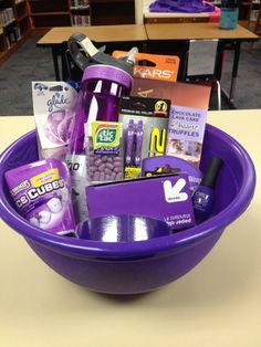 a purple bowl filled with lots of items on top of a table in a library