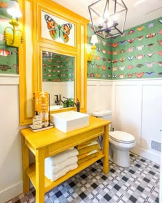 a bathroom with yellow and green wallpaper on the walls