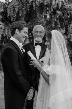 the bride and groom are smiling at each other as they hold hands during their wedding ceremony