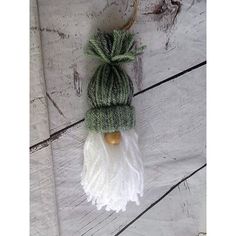 a green and white knitted hat hanging from a string