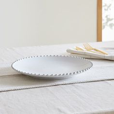 a white plate sitting on top of a table next to a fork and spoons