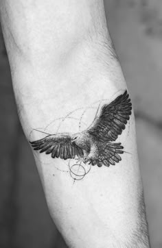 a black and white photo of an eagle tattoo on the left arm with circles around it