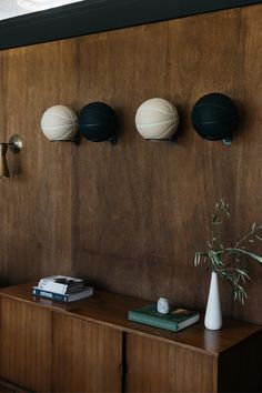 three black and white vases sitting on top of a wooden cabinet