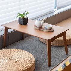 a wooden table sitting on top of a carpeted floor next to a potted plant