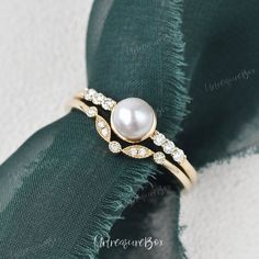 a close up of a ring with pearls on it's side and diamonds in the middle