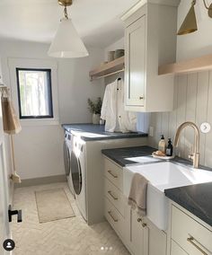 an image of a kitchen setting with white cabinets and black counter tops, including a washer and dryer