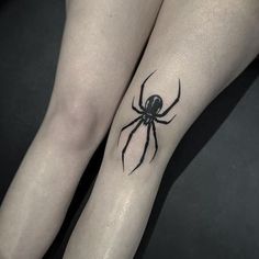 two legs with black spider tattoo on them