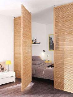 a bedroom with wooden slats on the walls and a bed in the corner between two doors