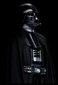 darth vader from star wars standing in the dark with his electronic device on