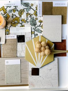 an assortment of different colors and materials on a white tray with a yellow candle in the middle