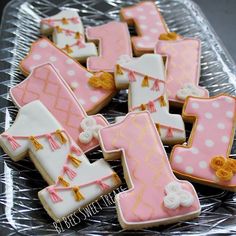 decorated cookies in the shape of letters and numbers on a clear plastic platter with gold trimmings