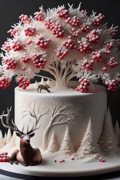 a cake decorated with white frosting and red berries on top is topped with an antler's head