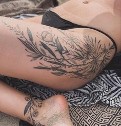 a woman laying on top of a towel covered in tattoos