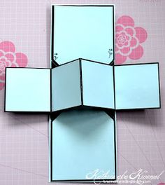 a cross made out of mirrors on a pink and white wall with flowers in the background