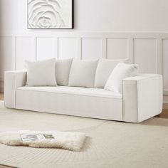 a white couch sitting on top of a rug in a living room