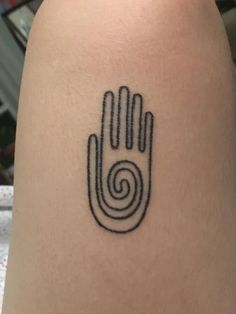 a tattoo on the arm of a person with a spiral design on their left hand