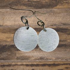 Exquisite Textured Silver Disc Earrings, perfect for those who adore the boho aesthetic. These captivating dangle earrings effortlessly blend rustic charm with a touch of minimalist elegance, creating a stunning accessory that will complement any outfit.  Embrace your bohemian spirit and the beauty of these unique earrings. A must-have addition to any jewelry collection, these Textured Silver Disc Earrings are truly timeless. Discs are 20mm, silver finish over brass. Hypoallergenic ear wires (ni Boho Aesthetic, Disc Earrings, Coastal Cowgirl, Unisex Jewelry, Trendy Jewelry, Men's Jewelry, Boho Chic Fashion, Minimalist Earrings, Unique Earrings