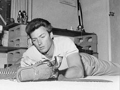 a man laying on the floor next to a pair of shoes