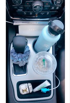 the interior of a car with various items in its place on the console and cup holder