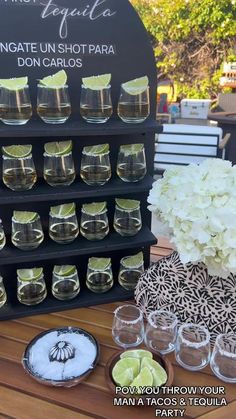 there are many glasses on the table and one is filled with lemons, limes, and other drinks