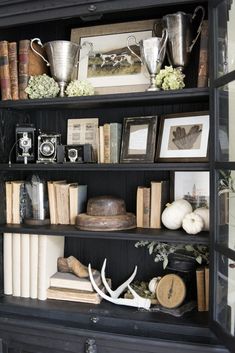 the bookshelf is filled with antique items and other things to collect in it