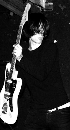 black and white photograph of a person holding an electric guitar