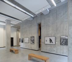 an empty room with benches and pictures on the wall