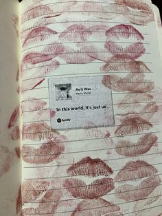 an open book with red lipstick drawn on it and the words in this world is just us