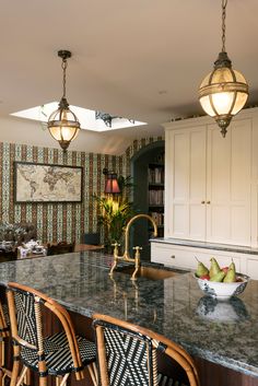 a kitchen with marble counter tops and wooden chairs