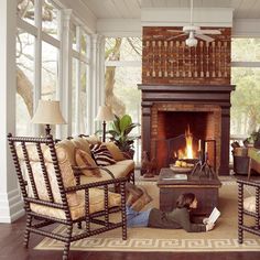 a person laying on the floor in front of a fire place with chairs and couches