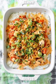 a white casserole dish filled with rice and vegetables