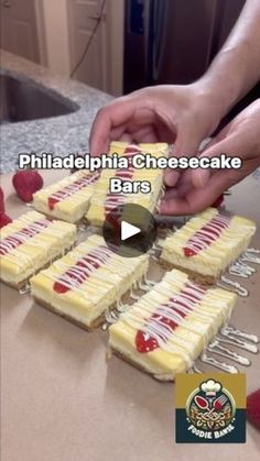 someone is cutting up some cheesecake bars on a counter top with raspberries