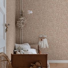 a teddy bear is sitting on the floor in front of a bed and wallpaper