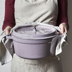 a woman in an apron holding a purple pot