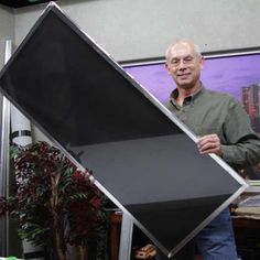 a man standing next to a large black object