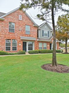 a large brick house with trees in front of it