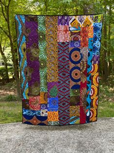 a colorful quilt sitting on top of a cement slab