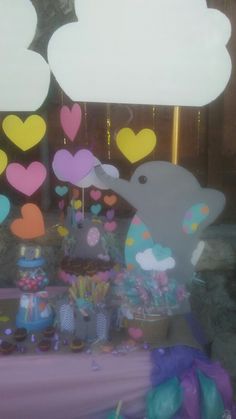 an elephant is standing in front of a table filled with balloons and other decorations for a baby shower