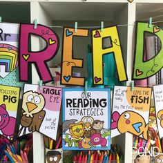 colorful posters are hanging on the wall in front of children's books and pencils