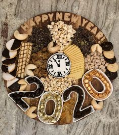 a clock made out of cookies and nuts with the words happy new year on it