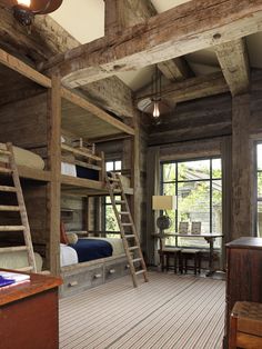 a bedroom with bunk beds and ladders on the floor in front of large windows