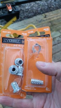 there are two pieces of screws in the package that is being held by someone's hand