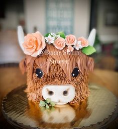 a cake shaped like a cow with flowers on its head