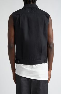 Takahiro Miyashita brings his antifashion perspective to a jacket-inspired vest crafted of jet-black cotton and designed with a variable front closure. 25" length (size 48) Front button closure Spread collar Chest button-flap patch pockets 100% cotton Hand wash, line dry Imported Designer Clothing Black Sleeveless Cotton Outerwear, Black Cotton Vest For Work, Modern Black Vest For Workwear, Modern Black Vest For Work, Modern Black Fitted Vest, Modern Fitted Black Vest, Modern Black Sleeveless Vest, Takahiro Miyashita, Faux Leather Vest